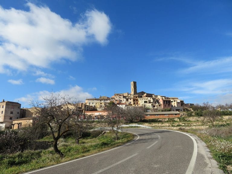 Panorámica de La Figuera desde la carretera, con el perfil del pueblo y su campanario al fondo en el Priorat