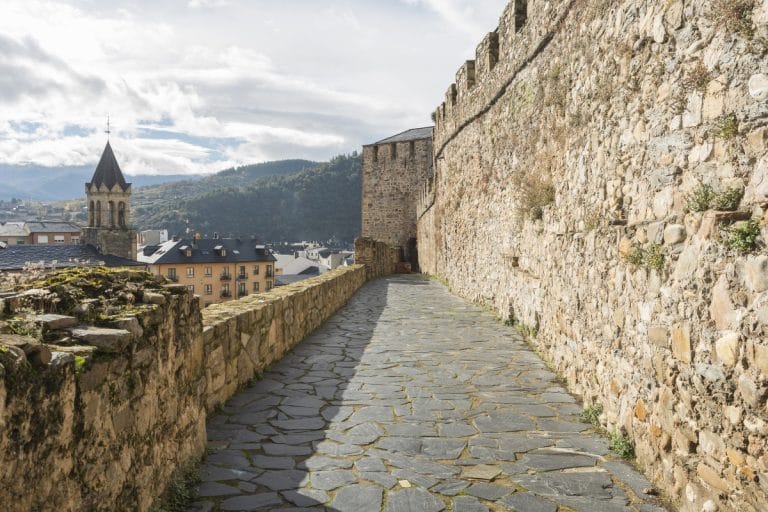Paseo por la muralla del Castillo de los Templarios de Ponferrada con vistas al casco urbano y las montañas del Bierzo.