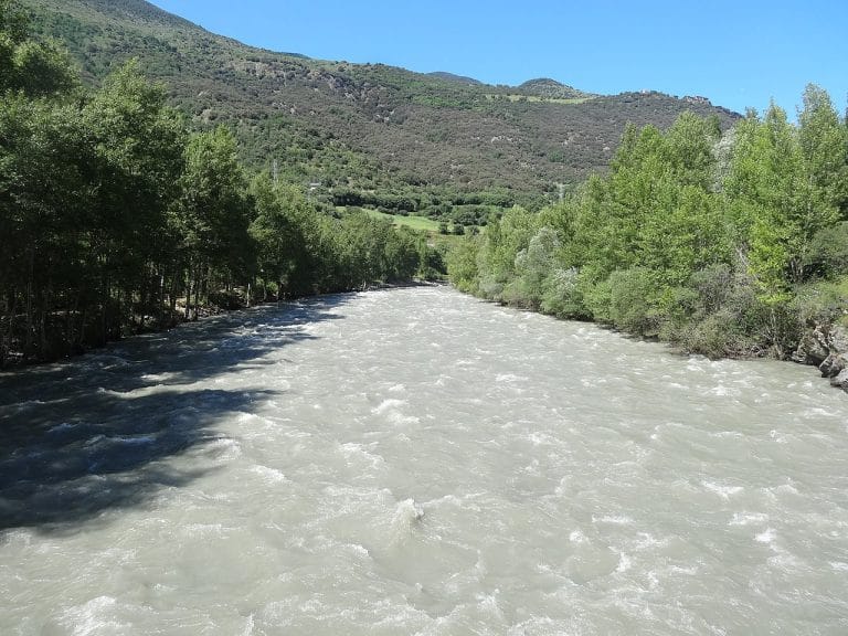 Río Noguera Pallaresa en Rialp, Lleida, con fuerte caudal rodeado de árboles y montañas del Pirineo