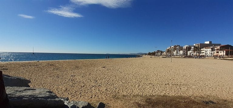 Playa de Bellamar en Premià de Mar con vistas al Mediterráneo y edificios costeros.