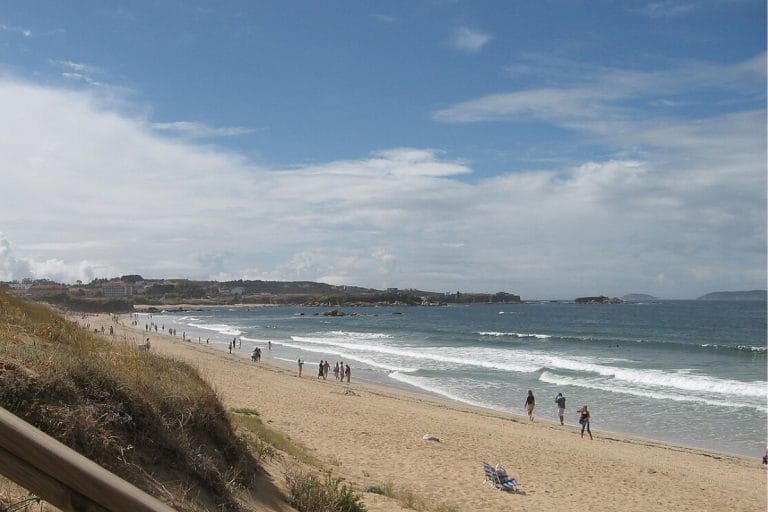Playa de A Lanzada en Sanxenxo y O Grove, Pontevedra, con arena dorada y mar abierto bajo cielo parcialmente nublado