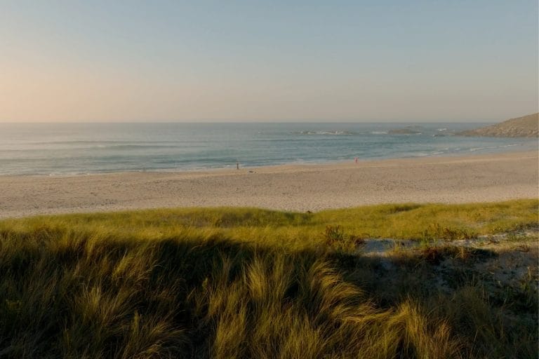 Playa de Laxe al atardecer, con dunas y mar tranquilo en la Costa da Morte, Galicia