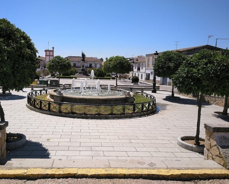 Plaza de Hernán Cortés con fuente central y monumento al fondo en Medellín, Badajoz
