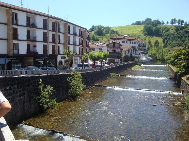 Vista del río Ezkurra atravesando el centro de Santesteban (Navarra), con edificios tradicionales a ambos lados.