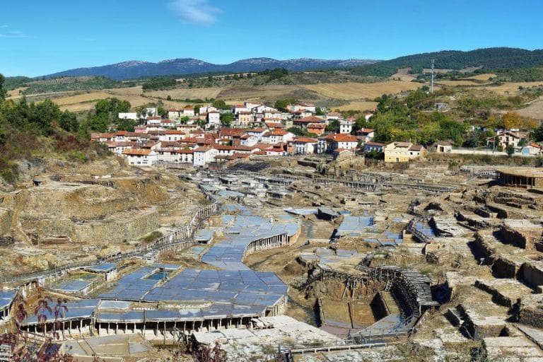 Vista panorámica del Valle Salado de Añana en Álava, con las salinas tradicionales y el pueblo al fondo rodeado de montañas.