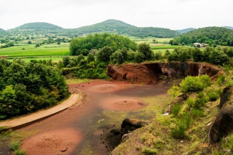 Vista del volcán del Croscat en la zona volcánica de la Garrotxa, con su característico cráter abierto y tierra rojiza.