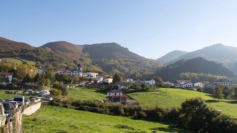 Vista panorámica del pueblo de Zugarramurdi rodeado de montañas verdes, en Navarra