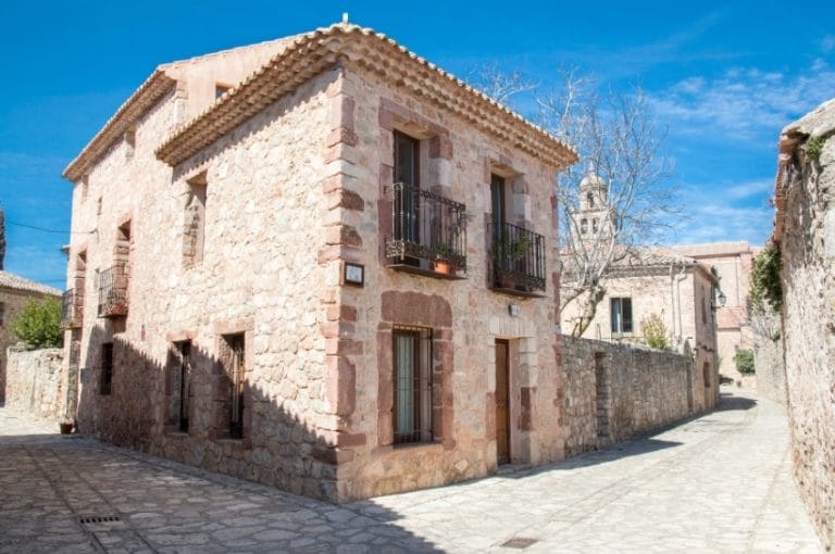Calle empedrada y casas de piedra en el casco histórico de Medinaceli, Soria