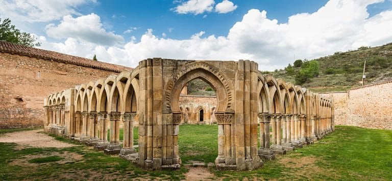 Claustro con arcos entrecruzados del Monasterio de San Juan de Duero en Soria rodeado de naturaleza