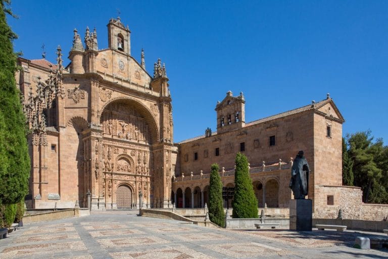 Fachada plateresca del Convento de San Esteban en Salamanca con estatua de Fray Luis de León en primer plano