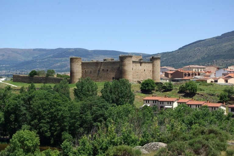 Castillo de Valdecorneja en El Barco de Ávila, fortaleza medieval rodeada de montañas y naturaleza.
