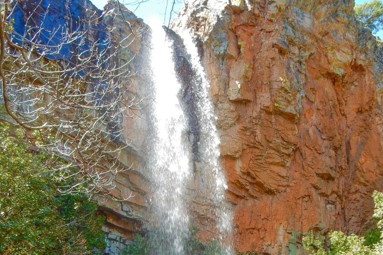 Cascada del Chorro en Salamanca, salto de agua cayendo desde un acantilado de roca rojiza rodeado de vegetación en plena naturaleza