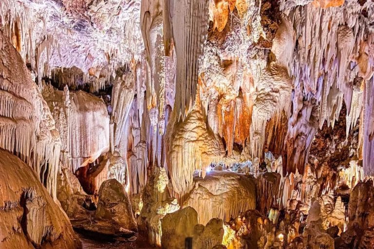 Interior de las Cuevas del Águila en Ávila con estalactitas iluminadas.