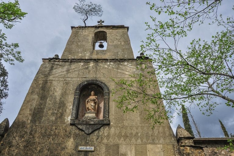 Fachada del Monasterio de San José en Las Batuecas, Salamanca, con torre campanario, estatua religiosa y entorno natural de gran valor histórico y espiritual