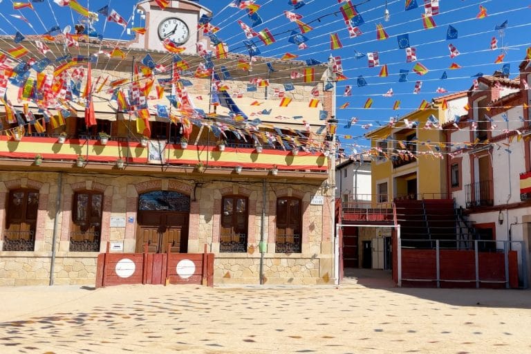 Plaza Mayor de Candeleda decorada con banderines y gradas para las fiestas locales.