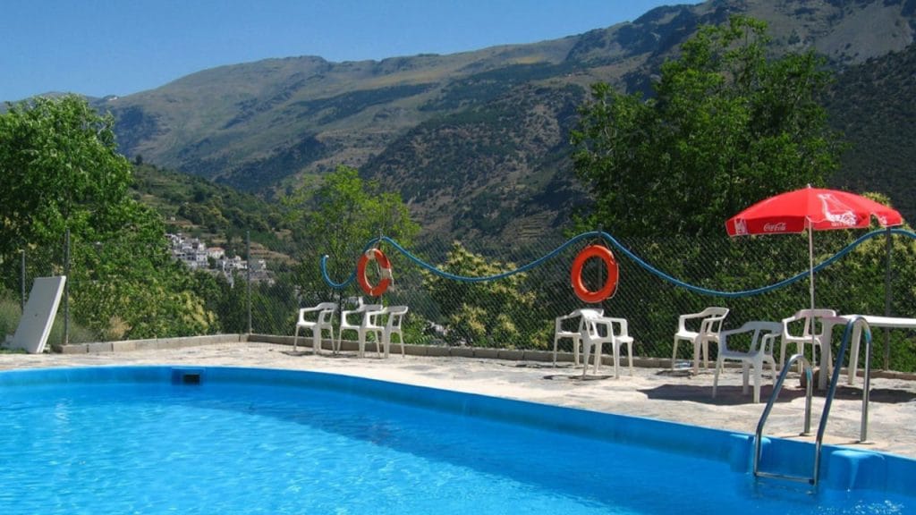 Piscina con vistas panorámicas en el Camping Tevelez. El lugar perfecto para refrescarse y disfrutar de la naturaleza durante tu estancia en Granada.