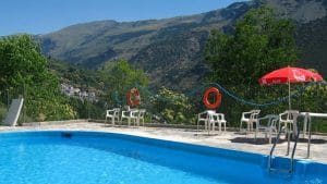 Piscina con vistas panorámicas en el Camping Tevelez. El lugar perfecto para refrescarse y disfrutar de la naturaleza durante tu estancia en Granada.